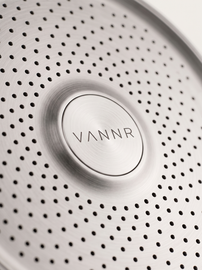 Macro detail of the perforated spray face and the etched VANNR wordmark.